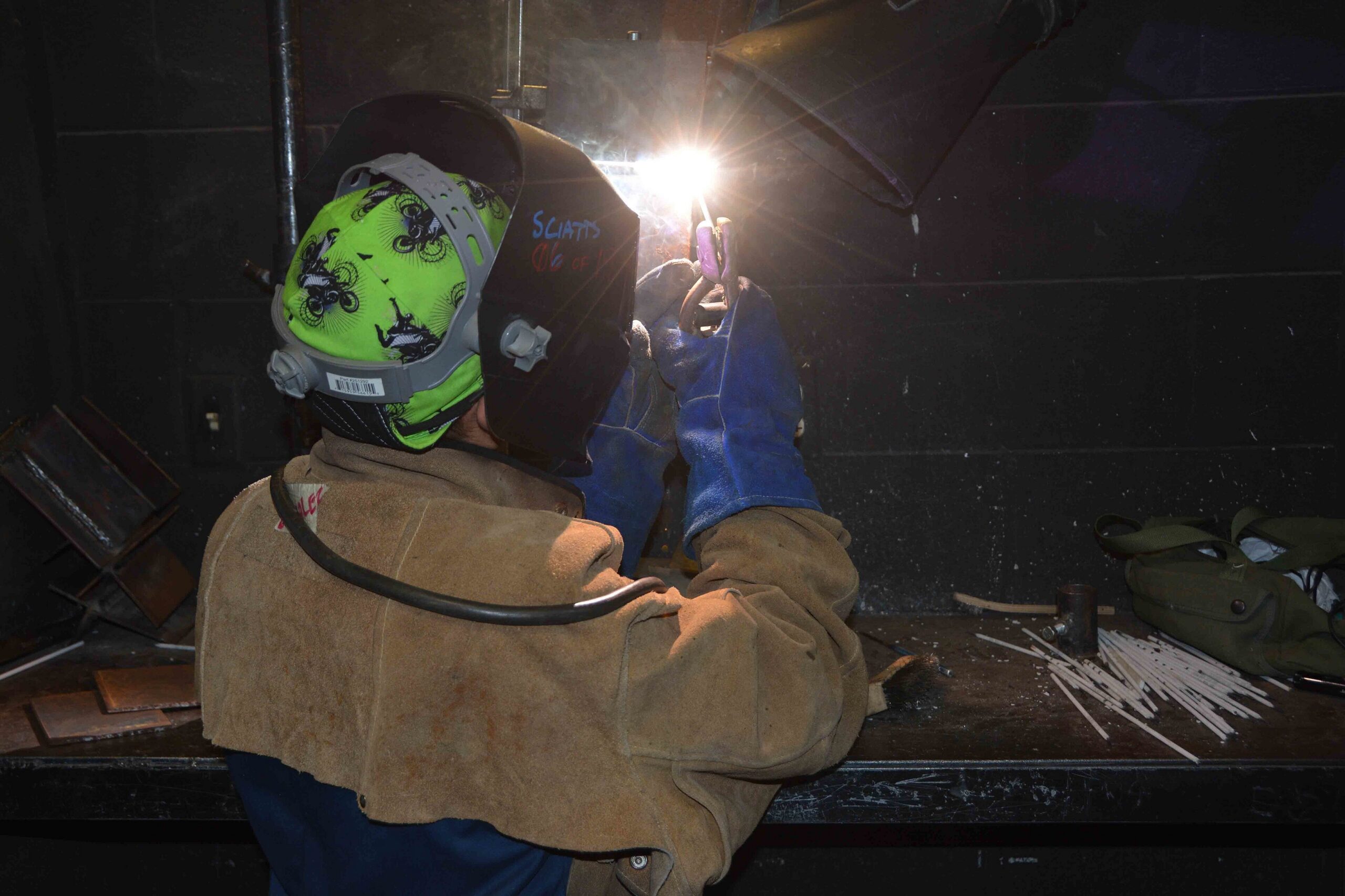 Trainee practising welding with protective equipment