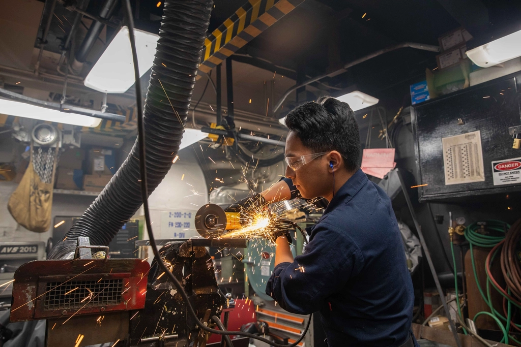 Technician using an angle grinder during mechanical maintenance work
